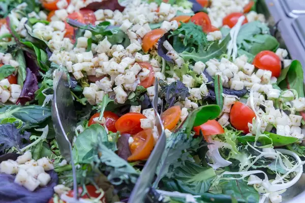 Salad with rocket, cherry tomatoes, spinach and small cheese cubes