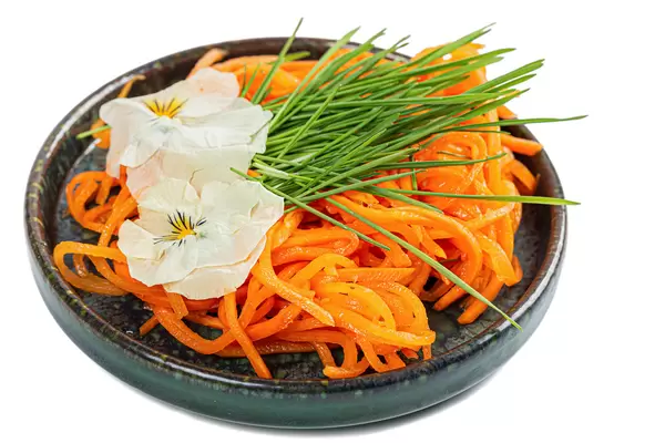 Salad with wheat sprouts, grated carrots and white edible flowers