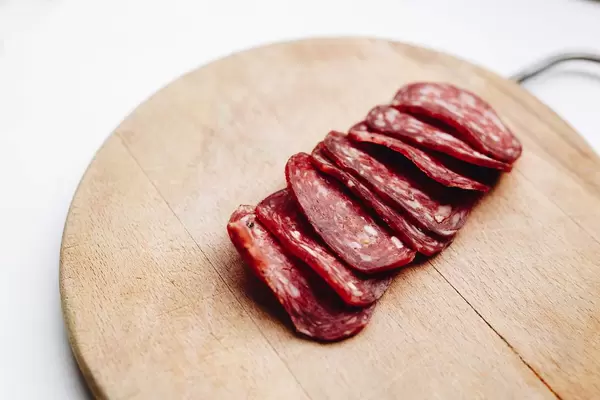 Salami slices on wooden cutting board. Close up