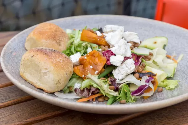 Salat mit Eisbergsalat, Rotkohl, Karotte, Zucchini, Kichererbse und Käse