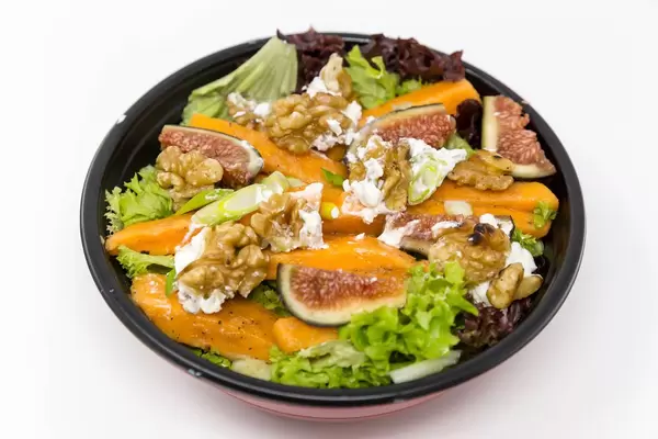 Salat mit Kürbis, Feigen, Walnüssen, Sellerie und Frischkäse in einer Schüssel  - Nahaufnahme