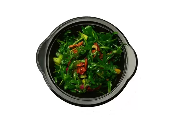 Salat mit Rucola, getrockneten Tomaten und Zucchini