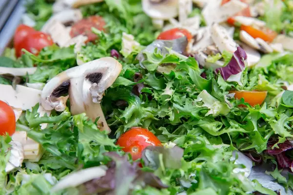 Salat mit Rukola, Cherrytomaten, Rotkohl, Champignons und Käse