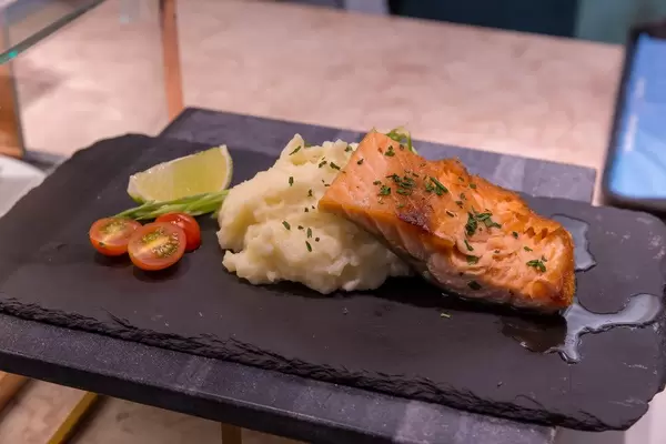 Salmon Filet with mashed potatoes, tomatos and lime served stone serving plate