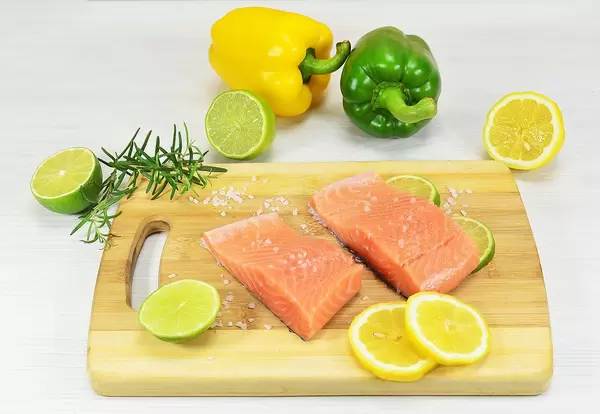Salmon Fillet on a Wooden Cutting Board with Lemon and Salt