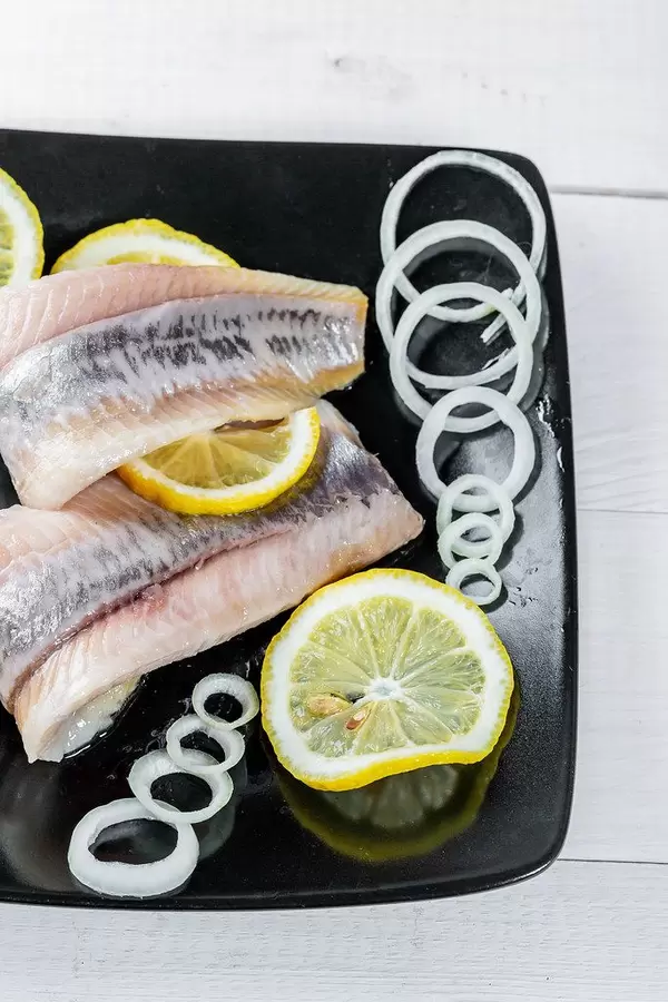 Salted herring with onion rings and lemon circles