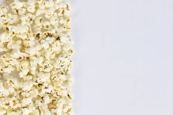 Salted popcorn grains on the white background