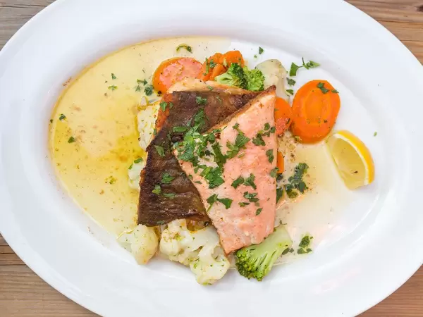 Salvelinus Alpinus oder Seesaibling, mit Gemüse und Kräutern serviert. Obene Aufnahme