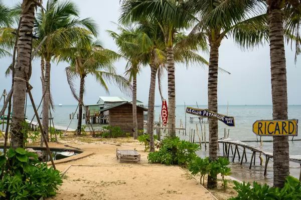 Sandstrand neben einem Naturschwimmbecken umgeben von Palmen bei Rory's Beach Club in Phu Quoc, Vietnam