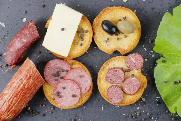 Sandwich mit Salami, Käse, Oliven und Pfefferkörner