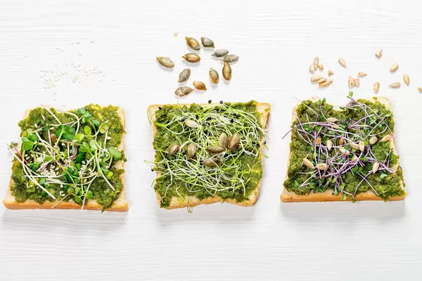 Sandwich with herbs, micro greens and seeds on white wooden background (Flip 2019)