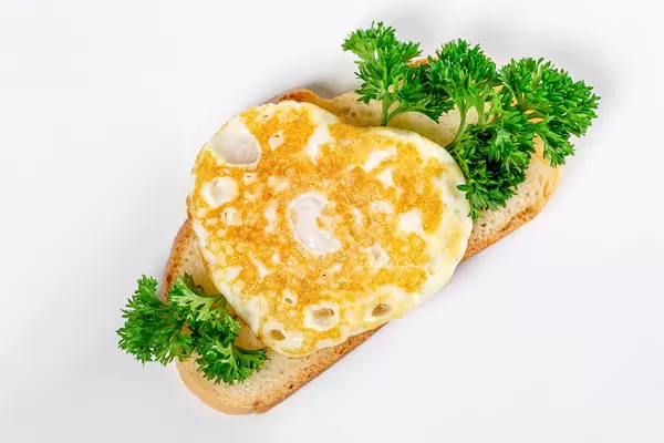Sandwich with white bread, fried egg and parsley
