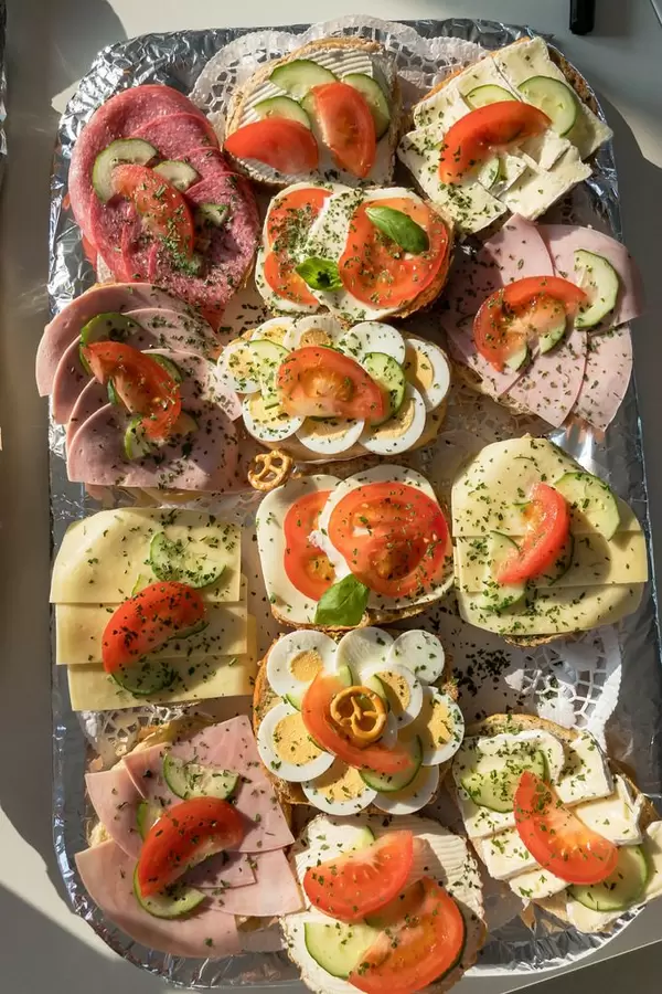 Sandwiches mit Eiern, Käse, Aufstrich, Schinken und Wurst