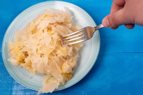 Sauerkraut on the plate and fork in the hand (Flip 2020)