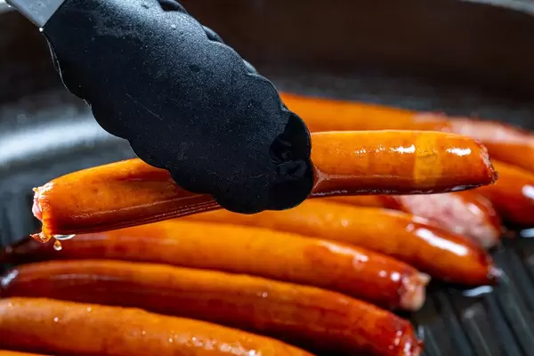 Sausages frying in a skillet
