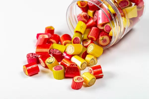 Scattered fruit colored lollipops on a white background (Flip 2020)