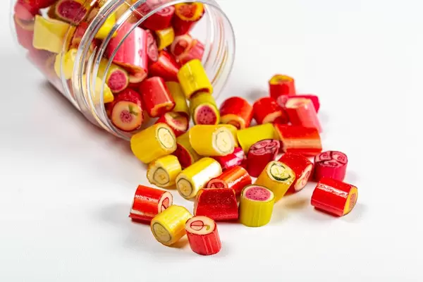 Scattered fruit colored lollipops on a white background