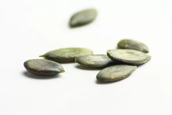 Scattered pumpkin seeds on a white background