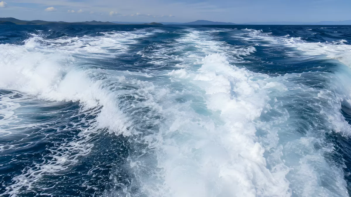 Schäumendes Kielwasser eines Schiffes auf blauem Meer