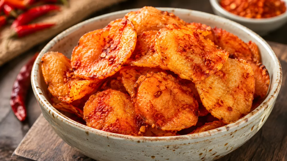 Scharfe Kartoffelchips mit Chili in Keramikschüssel