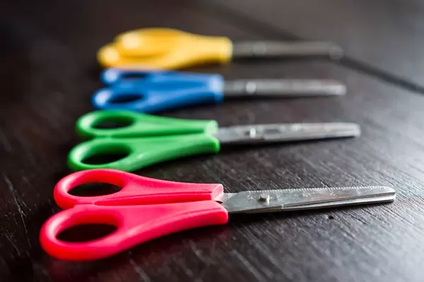 Scheren in verschiedenen Farben auf einem Holztisch