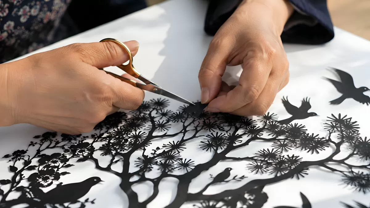 Scherenschnitt-Kunst mit Vögeln und Ästen in Arbeit