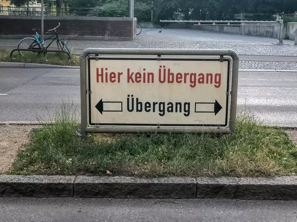 Schild mit dem Text "Hier kein Übergang" zeigt den richtigen Kurs auf einer Straße von München