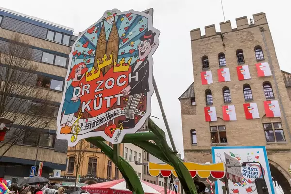 Schild mit Schrift "D'r Zoch kütt" ("Der Zug kommt" in Kölsch) führt den Rosenmontagsumzug in Köln