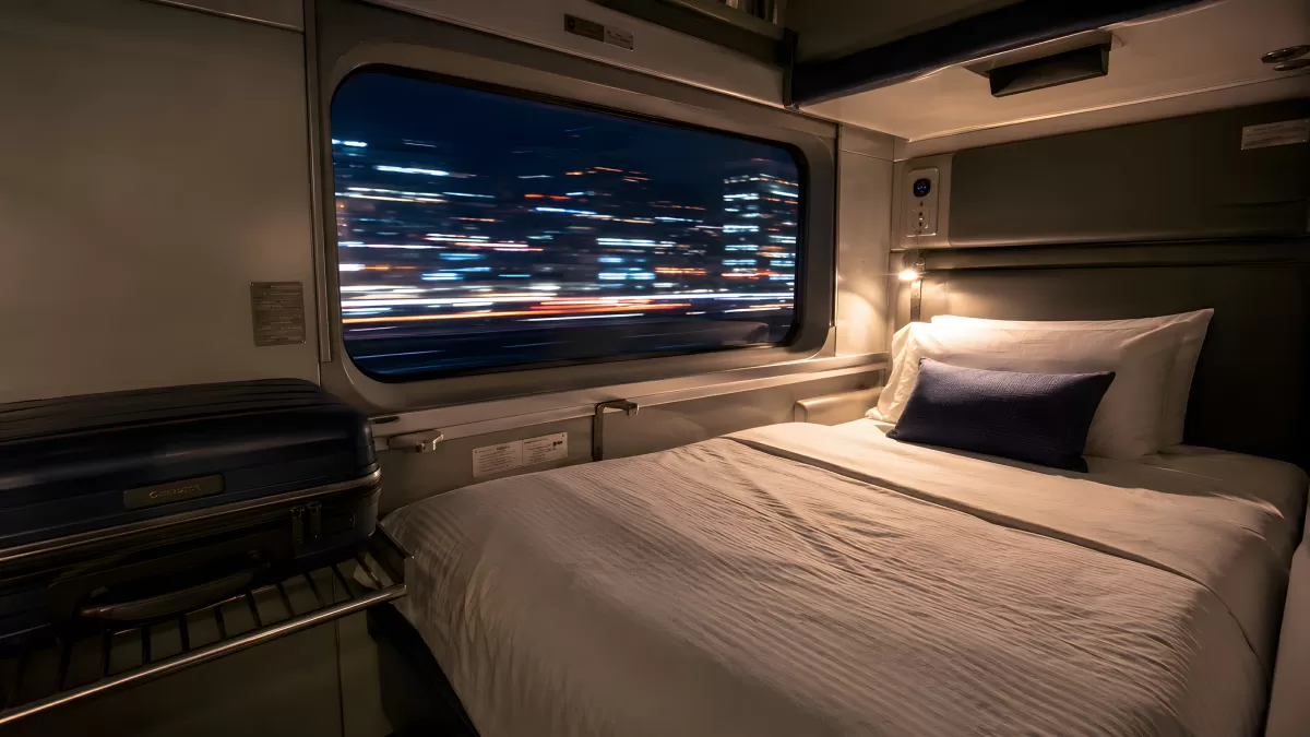 Schlafabteil im Nachtzug mit Stadtlichtern bei Nacht