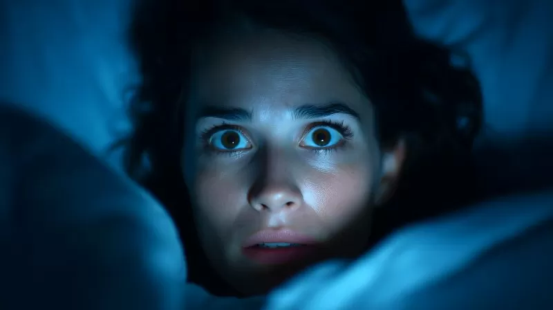 Schlaflosigkeit: Frau liegt wach mit weit geöffneten Augen im Bett