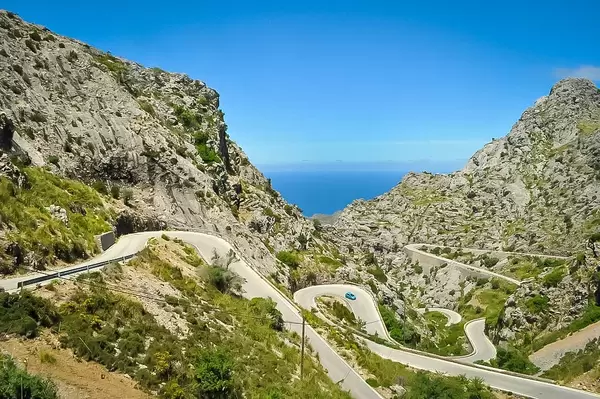 Schlangenstraße im felsigen Gebirge, mit dem Meer im Hintergrund