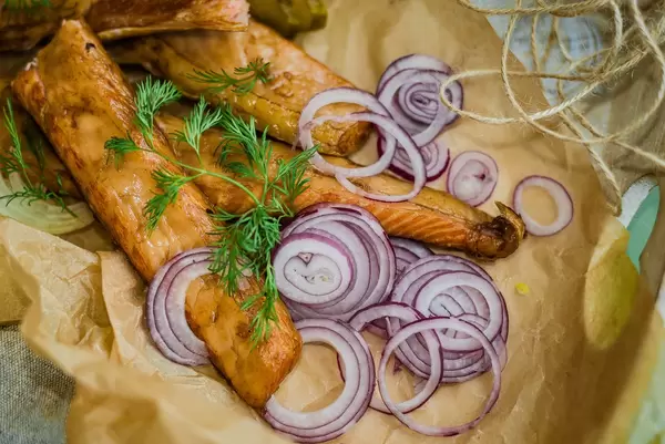 Schmackhafte geräucherte Lachsstreifen mit Zwiebelringen und Kräutern