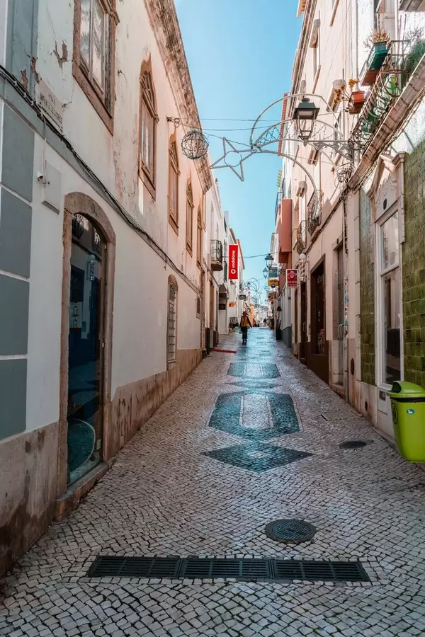 Schmale Gasse Rua Silva Lopes in Lagos, Portugal mit alten Pflastersteinen mit eingearbeitetem Muster
