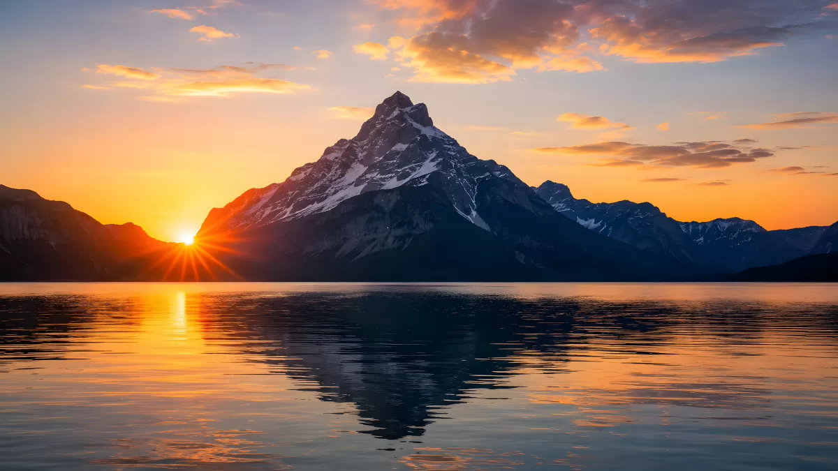 Schneebedeckter Berggipfel spiegelt sich im See bei Sonnenuntergang
