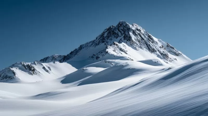 Schneebedeckter Berggipfel unter blauem Himmel