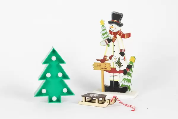 Schneemannfigur und Holzschlitten mit Weihnachtsbaum auf weißem Hintergrund