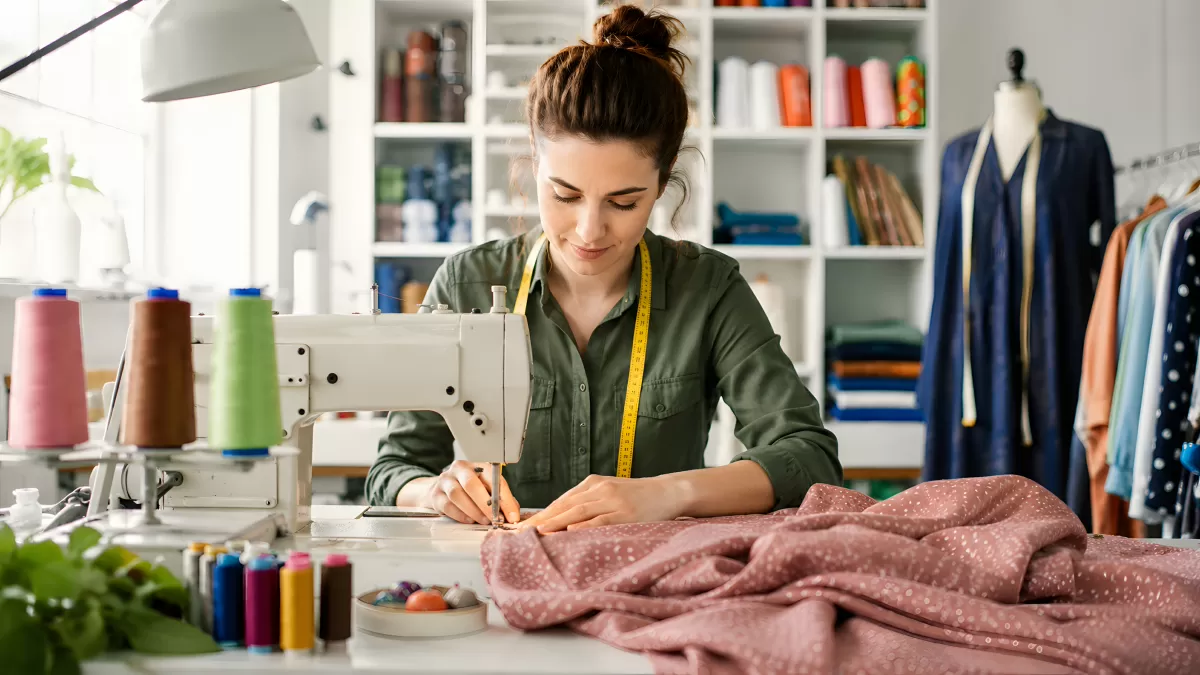 Schneiderin arbeitet konzentriert an Nähmaschine im Atelier