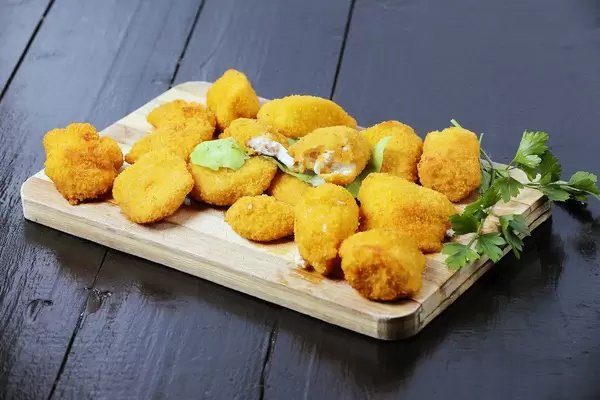 Schnelles Mittagessen: Chicken Nuggets auf einem Holzbrettchen