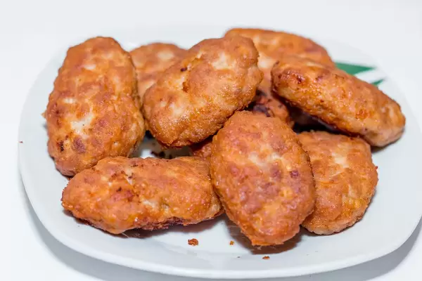 Schnitzel aus goldgelb gebratenem Fleisch auf weißem Teller