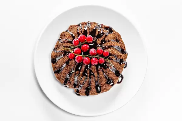 Schoko-Cupcake mit roten Waldfrüchten und Schoko-Topping: Aufnahme von oben auf weißem Hintergrund