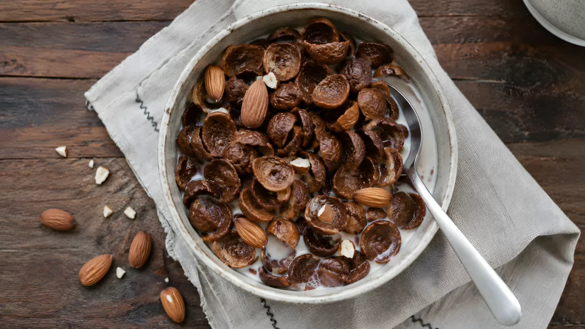 Schokoladencerealien mit Mandeln und Milch in Schüssel