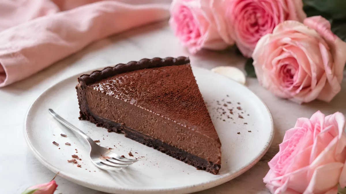 Schokoladentarte mit Kakaopulver und rosa Rosen