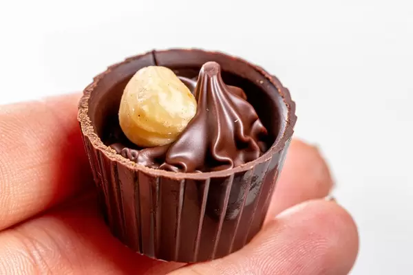 Schokopraline mit Haselnusscreme auf einer Frauenhand