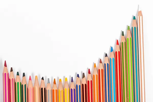 School background with many colorful pencils on white background