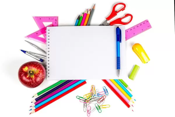 School supplies and red apple on white, colored school background