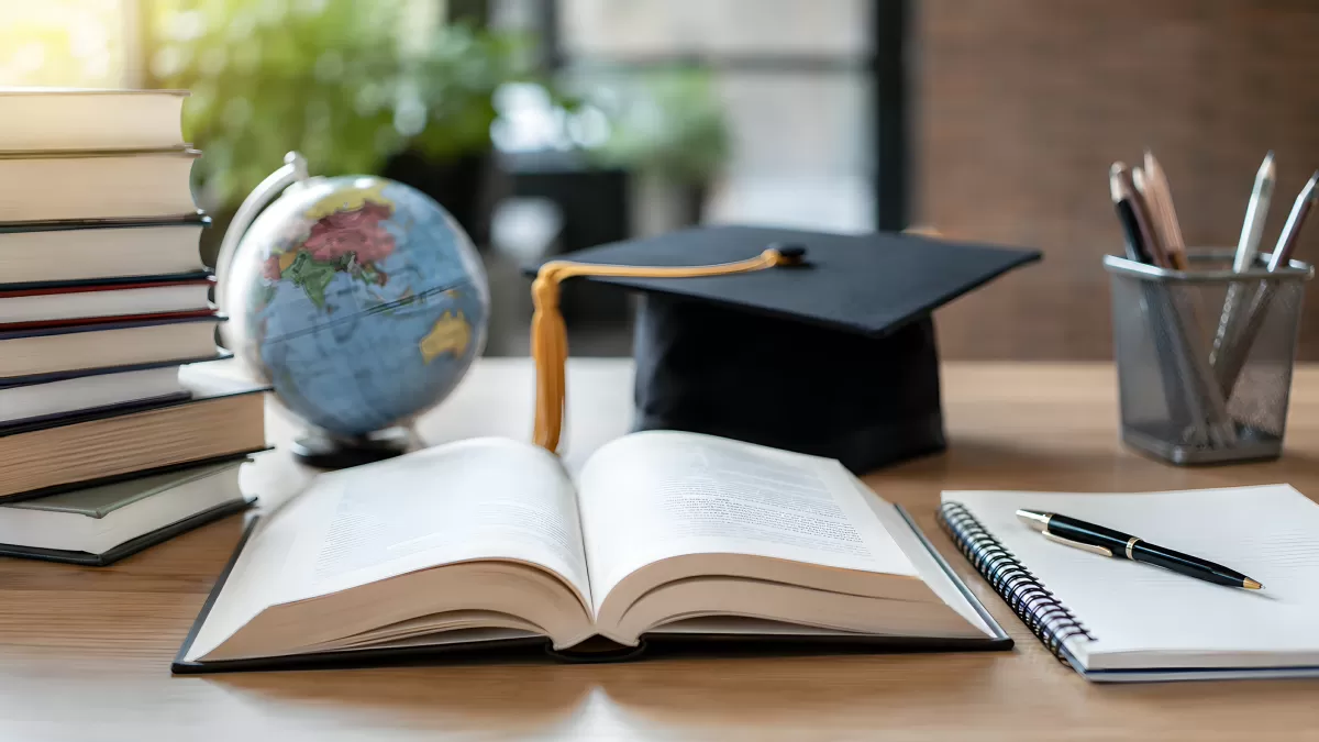 Schreibtisch mit Büchern, Globus und Abschlusskappe