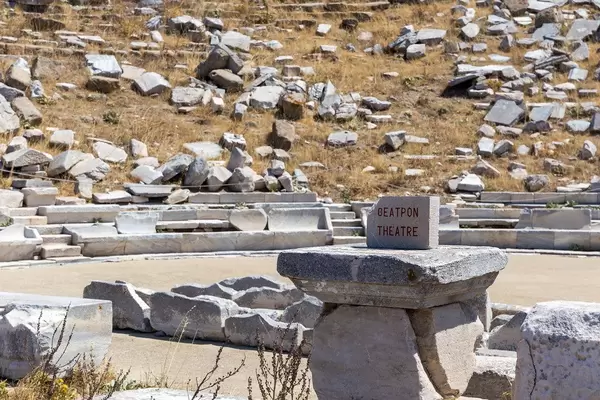 Schrift auf Griechisch und Englisch auf einem Stein beim antiken Theater von Delos