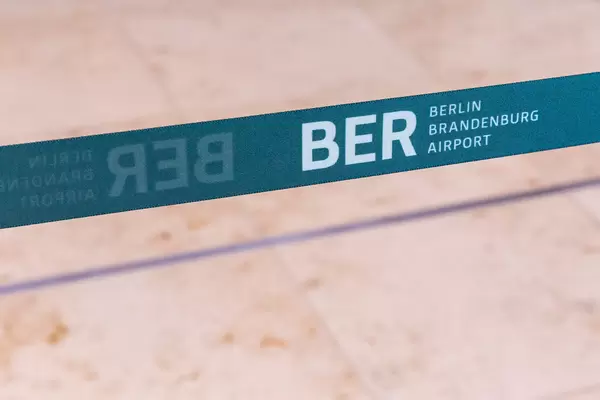 Schrift und Logo "BER Berlin Brandenburg Airport" auf einem blaugrünen Band am neuen Flughafen