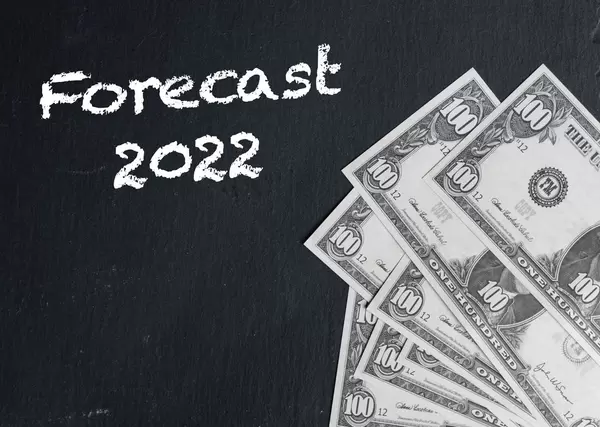 Schriftzug FORECAST 2022 (Prognose 2022) neben Dollarnoten auf schwarzem Hintergrund