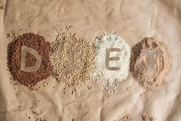 Schriftzug "Diet" (deutsch: Diät) im Getreide, bestehend aus natürlichem Buchweizen, Gerste und Reis, auf braune Backpapier